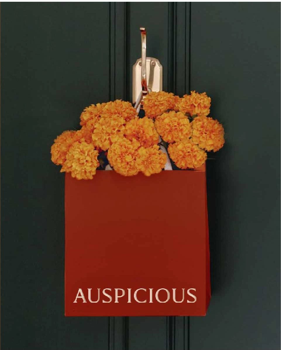 Auspicious Living red shopping bag filled with marigolds